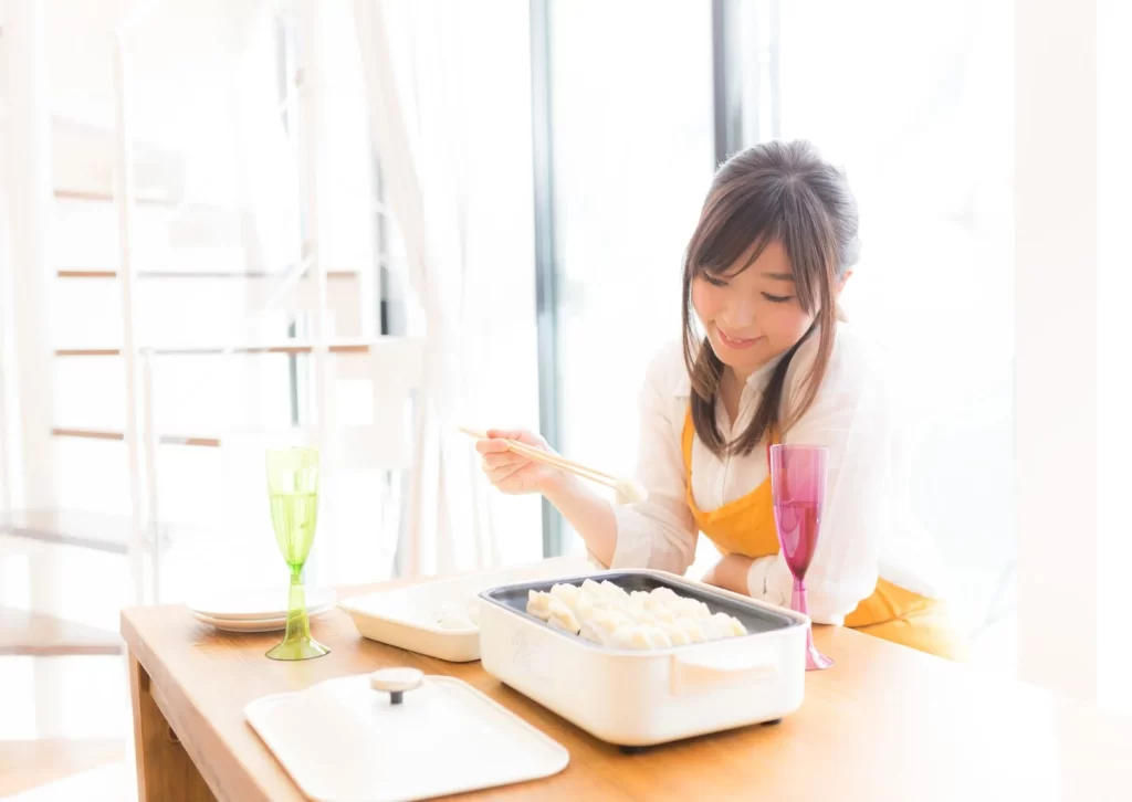 ホットプレートで餃子を焼く女性