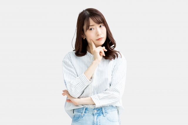 悩んでいる白シャツの女性