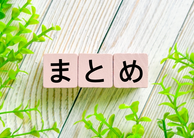 木の板の上のフェイクグリーンと「ま」「と」「め」と書かれた木のブロック３つ