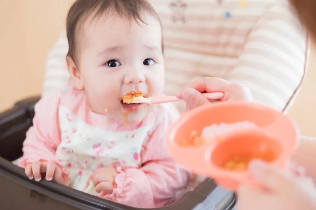 離乳食を食べる女の子の赤ちゃん
