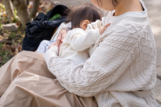 授乳しているニットを着たママと赤ちゃん