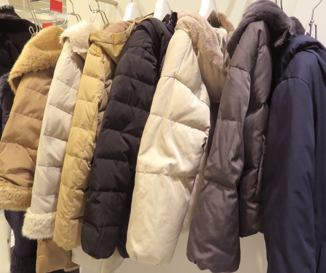 ハンガーにかけられた複数のダウンコート