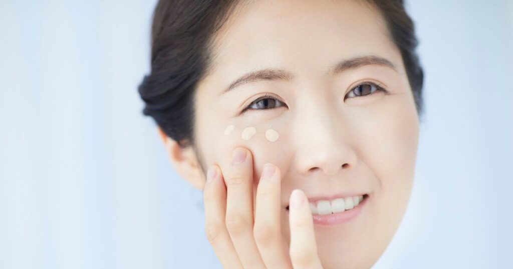 頬にファンデーションを塗る女性