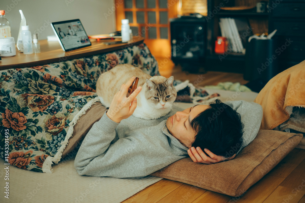 猫とこたつでくつろぐ男性