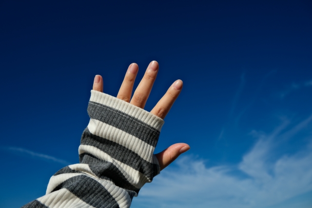 アームカバーをしている手と空