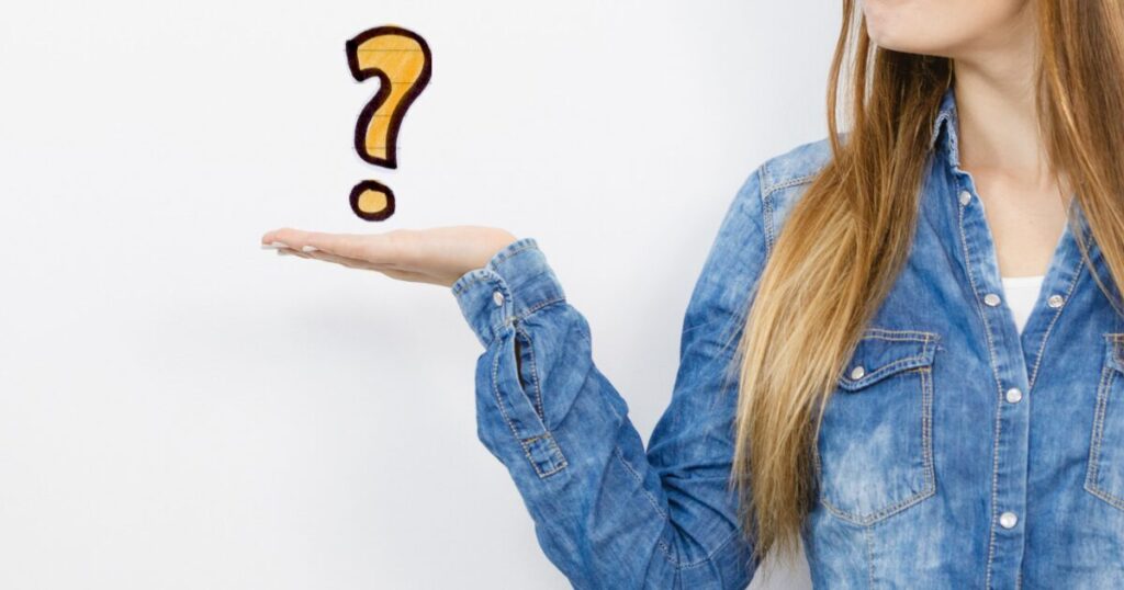 デニムシャツ姿で手のひらの上のはてなを見つめる女性
