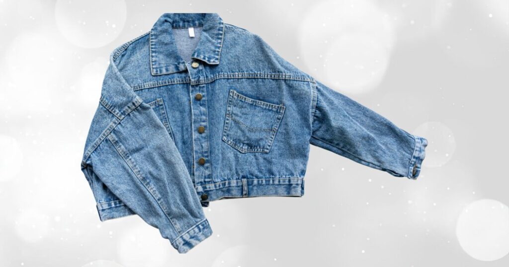 キラキラとした光の背景に置かれたゆったりシルエットのデニムジャケット
