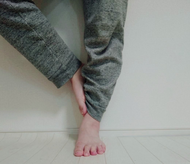 グレーのスウェットパンツを穿いた足