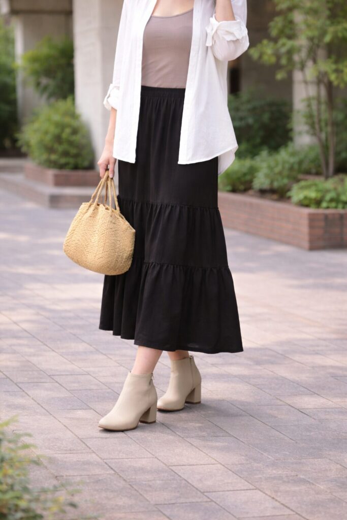 ゆるめのトップスとロングスカートとショートブーツコーデの女性