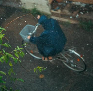 雨の中レインコートを着ている女性