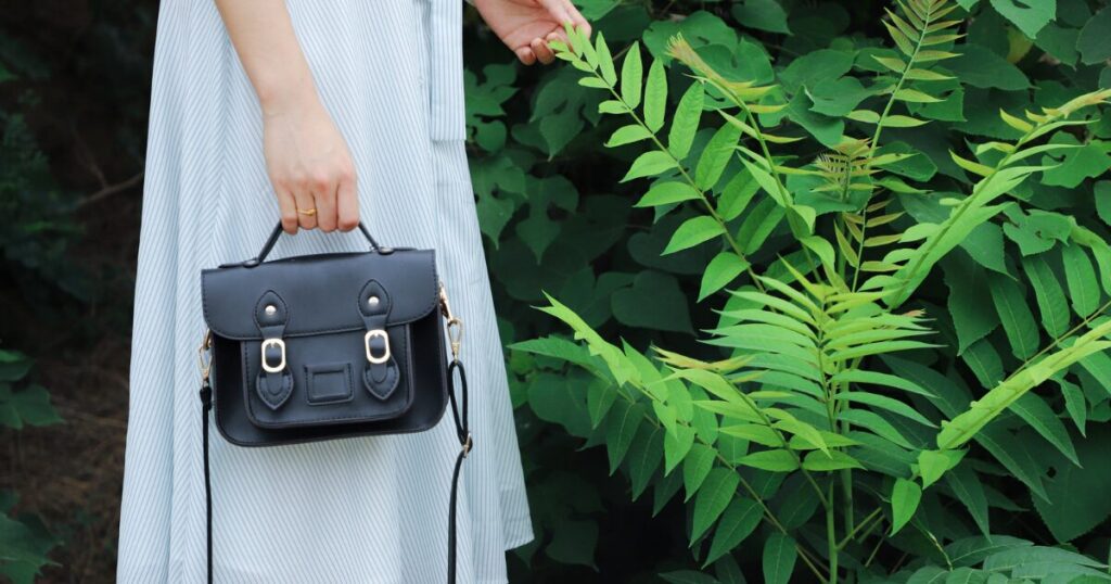 白いワンピースの女性と黒いバッグ