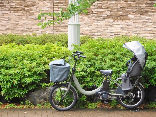 前かごカバーと日よけ付きのチャイルドシートを備えた電動自転車