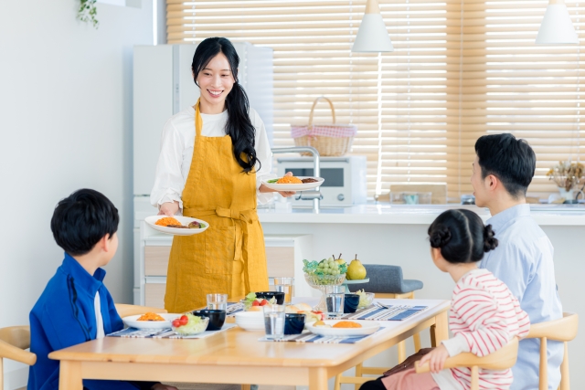 食卓を囲んで家族で食事を楽しんでいる