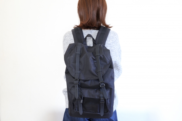 女性がリュックサックを背負っている