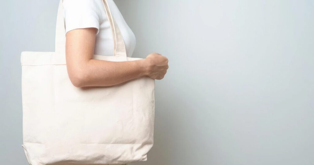 白いトートバッグを肩掛けしている女性