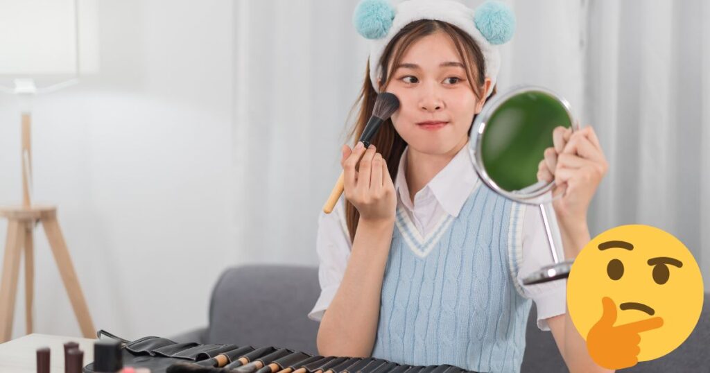 鏡を見て化粧をしている女性