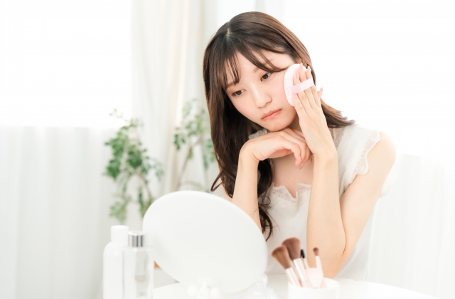 化粧をしながら鏡を見ている女性