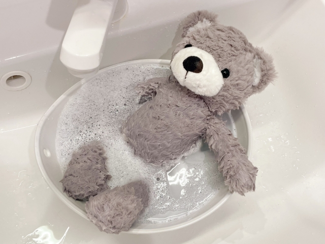 桶で洗われているくまのぬいぐるみ