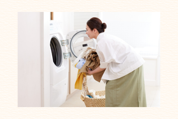 洗濯機を開けて洗濯物を出す女性