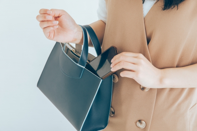 黒いバッグから荷物を取り出す女性