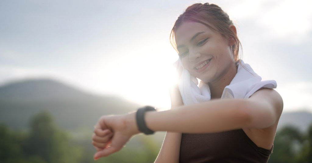 汗を拭きながら、手首の黒い腕時計を見る女性