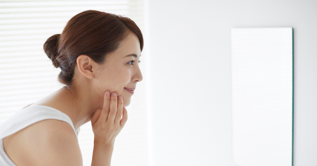 鏡で自分の顔をチェックする女性