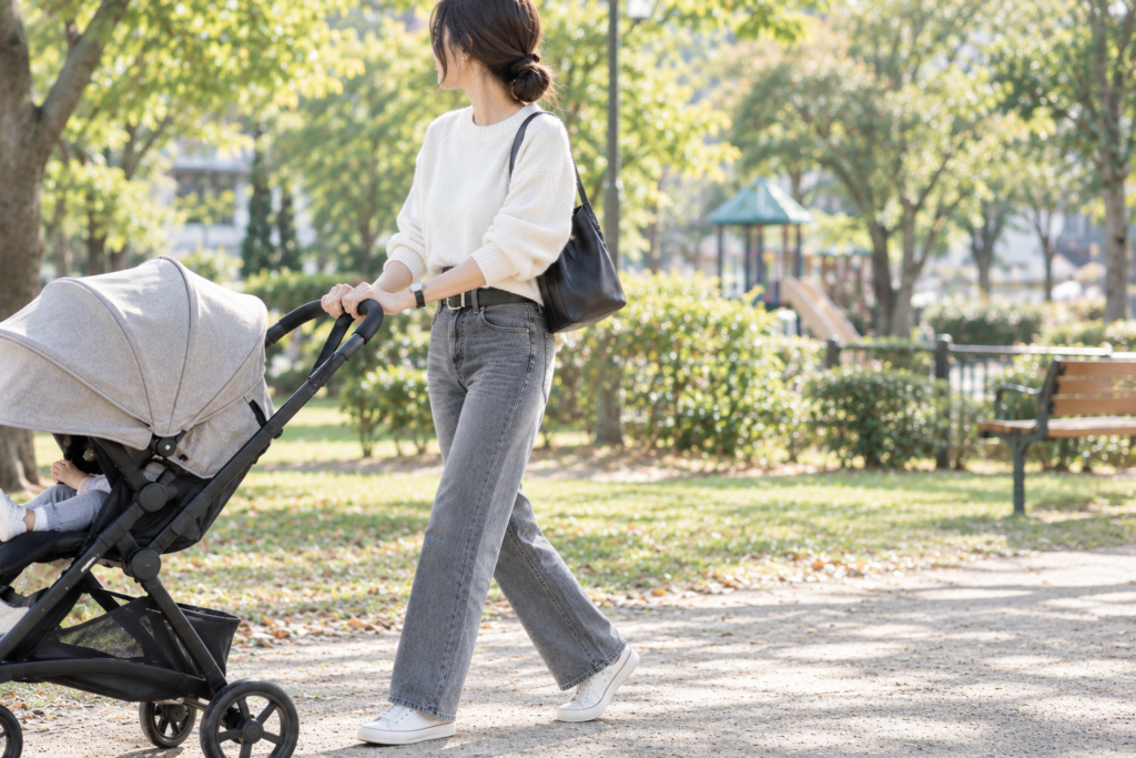 公園をベビーカーをおして散歩する女性